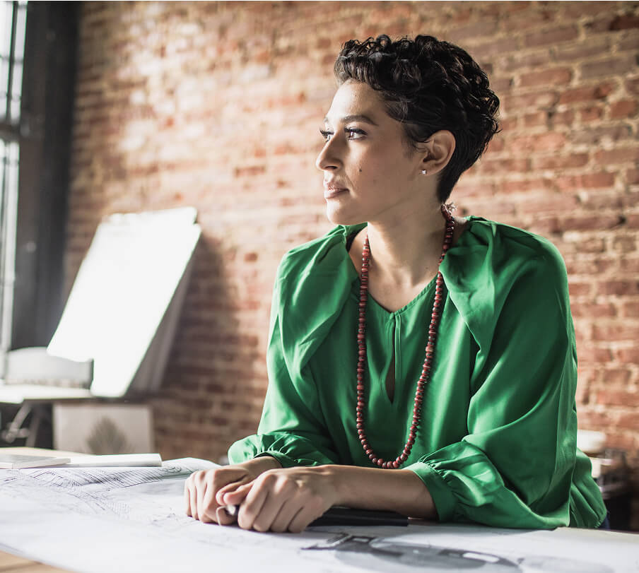  Businesswoman looking over architecture blueprints